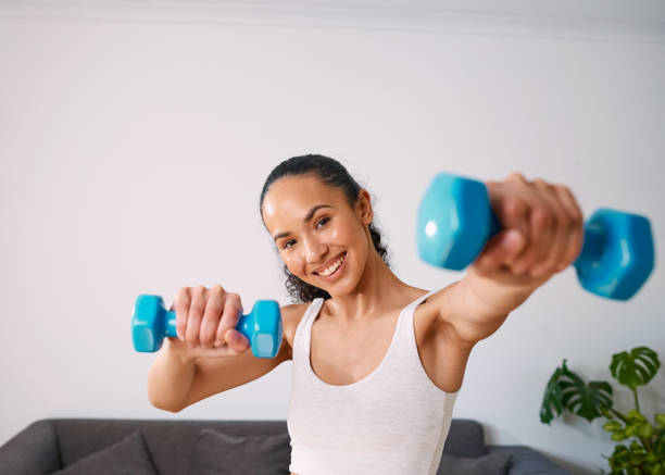 istock A young woman smiles while holding 2kg weights at home 1412413732