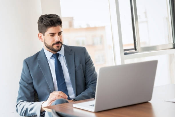 istock Shot of businessman using laptop while working at the office 1412413797