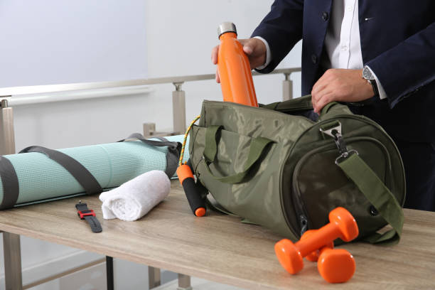 businessman packing sports stuff for training into bag in office, closeup - men exercising equipment relaxation exercise imagens e fotografias de stock