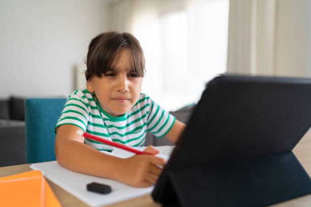 istock Child sitting alone at home and feeling stressed while doing her homework 1412414961