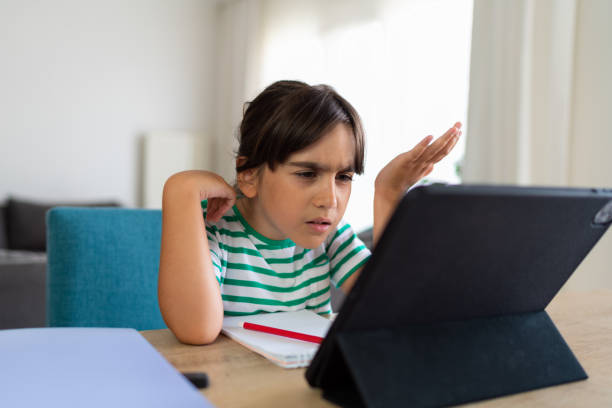 istock Child sitting alone at home and feeling stressed while doing her homework 1412415023