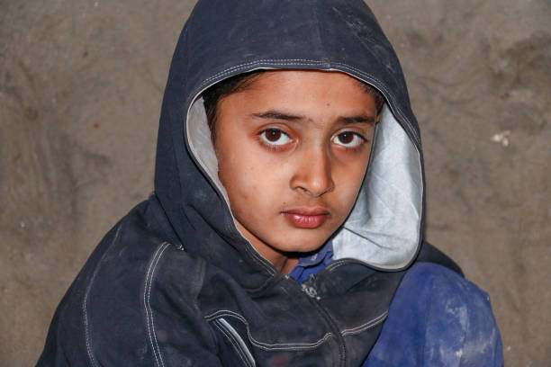 istock poor Asian child boy looking to camera with sad face 1412415057