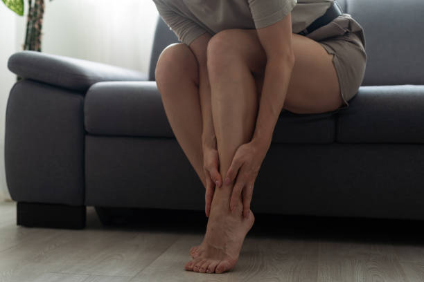 istock a woman is holding her leg 1412415712