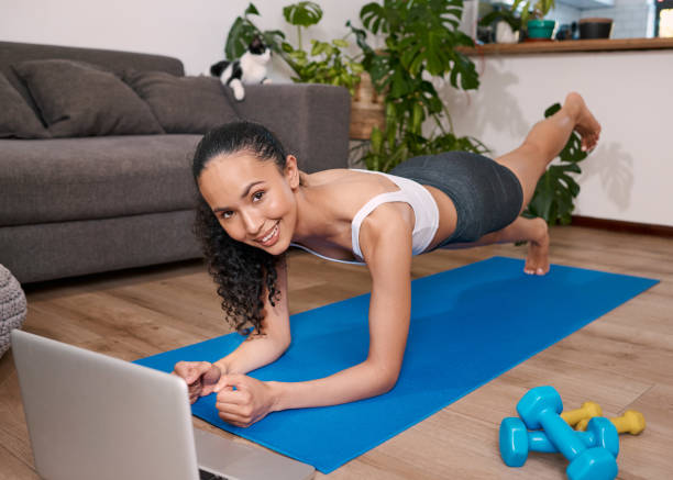 istock A young multi-ethnic woman does a raised leg push up in her home 1412415734