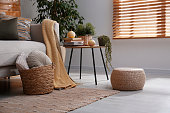 istock Stylish living room interior with comfortable sofa and wicker pouf 1412415874
