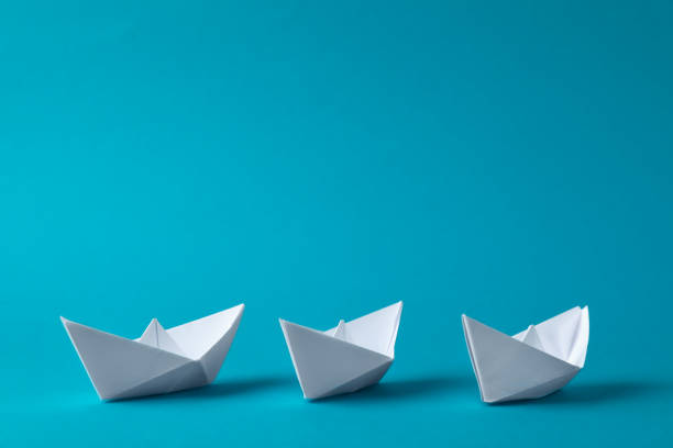 istock Handmade white paper boats on light blue background. Space for text 1412416456