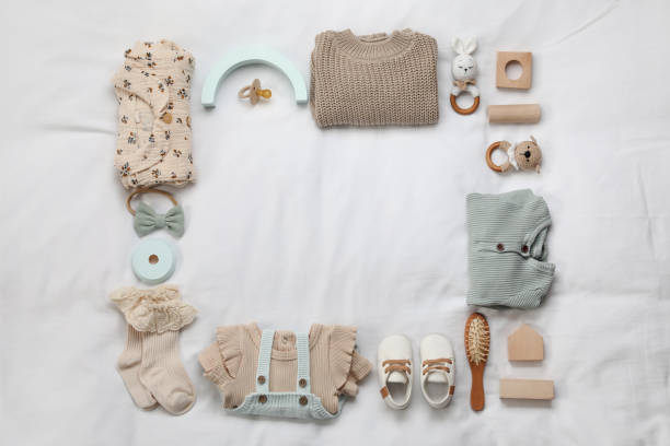 istock Layout with baby outfit and cute accessories on white bed, top view. space for text 1412417070