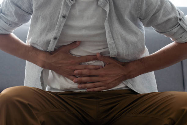 istock man having a stomach ache. Problems and health care concepts 1412417217