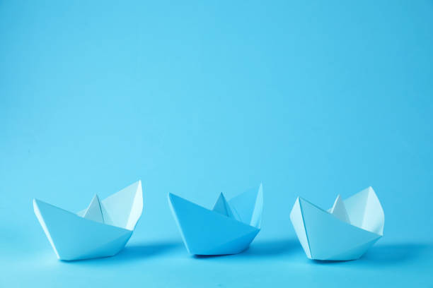 istock Handmade paper boats on light blue background.  Space for text 1412417276