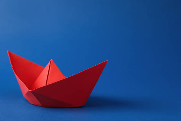 istock Handmade red paper boat on blue background. Space for text 1412417406