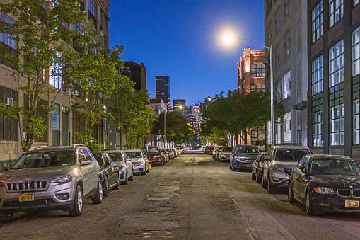View up a 43rd Avenue to high rise buildings in Long Island City at a hot summer night