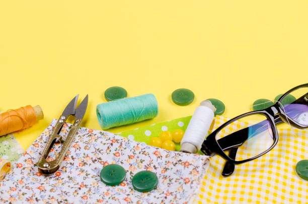 A set of sewing accessories for sewing, spools of thread, fabrics, scissors, thimble and glasses. Tailoring concept, patchwork and handwork.  Needlework and Sewing.