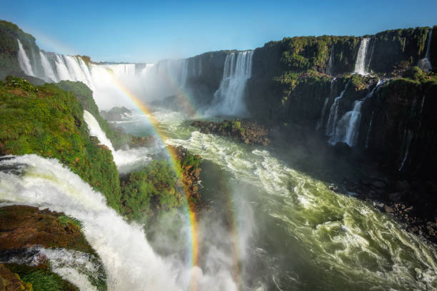 cachoeira do iguaçu na fronteira do brasil com a argentina - tropical rainforest waterfall rainbow iguacu falls - fotografias e filmes do acervo