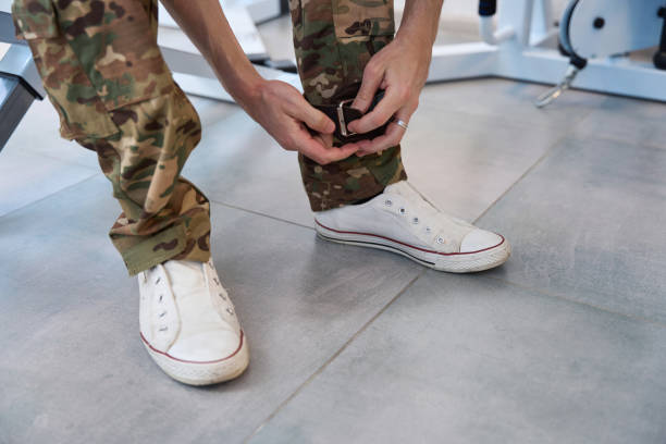 istock Man puts his leg special fixing cuff for exercising simulator 1412421998