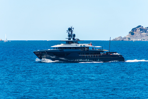 Blue and white luxury yacht in motion on Mediterranean sea in front of the Palmaria island, Porto Venere or Portovenere, Gulf of La Spezia, La Spezia, Liguria, Italy, southern Europe.