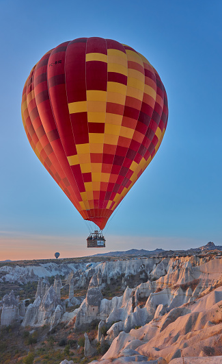 Goreme, Turkey - October  25, 2020: Colorful hot air balloons flying early in the morning over the valley at Cappadocia, Nevsehir, Turkey.