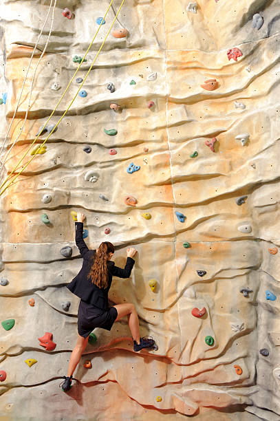 business woman on rock wall stock photo