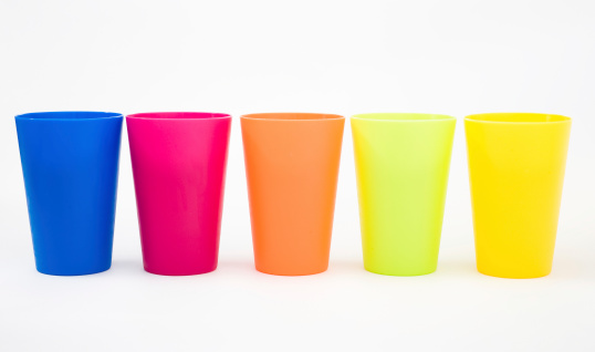 Plastic cups of various color isolated on white.