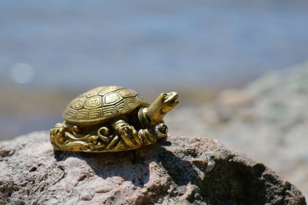 istock A metal turtle on the riverbank. 1412428330