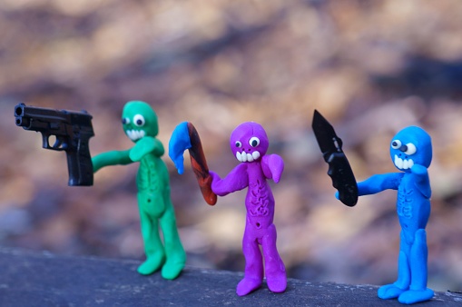 Figures of three zombies armed with a gun, a knife and an axe. Zombie apocalypse. Invasion of monsters.