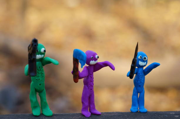 istock Figures of three zombies armed with a gun, a knife and an axe. 1412428677