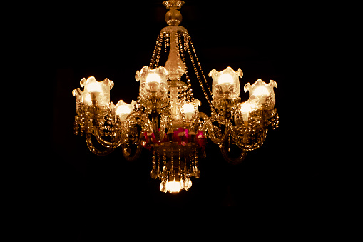 This is a shot taken of a Glass chandelier. The dark background enhances its inherent beauty