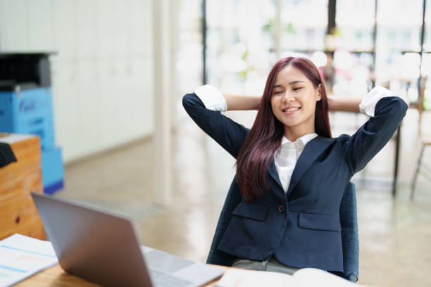 istock cheerful Asian  celebrating her victory online with her laptop 1412430557