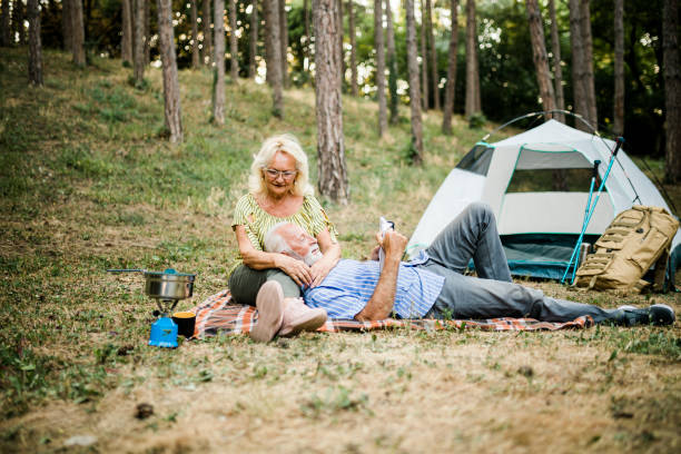 istock Senior couple enjoying a book on the camping 1412430729