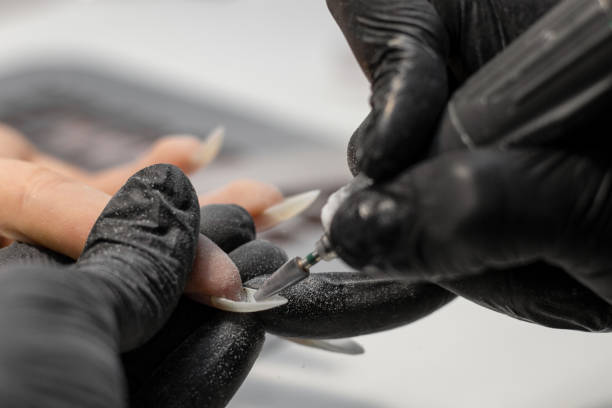 istock The process of creating a manicure. Master works electric cutter for nails. 1412431788