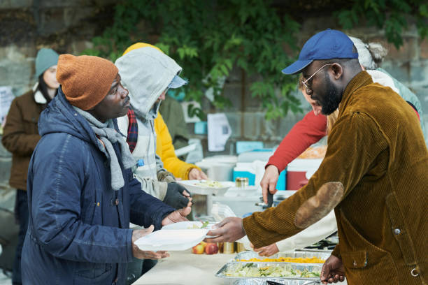 compartir alimentos con las personas sin hogar - homelessness men white black fotografías e imágenes de stock