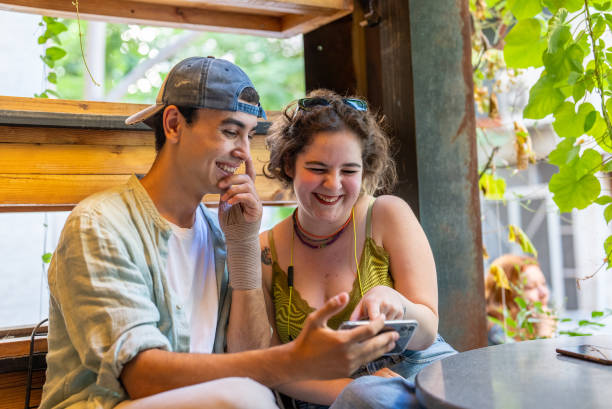 istock Young friends watching mobile device screen in a cafe 1412432259