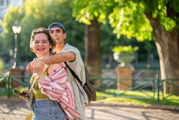 Close-up portrait of couple in love. Young woman and men walking and having fun in park on warm summer day. Vertical photo. High quality photo