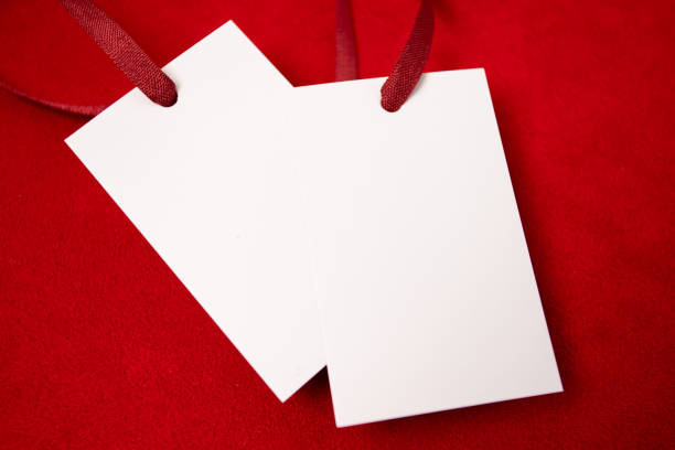 istock Modern advertising for cloth design. Clothes tag mock up white on red fabric. Modern design. Red fabric pattern background. Price tag. 1412432858