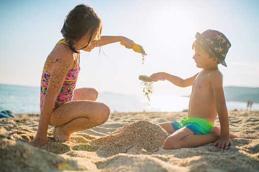 Little girl and boy enjoying beach holidays