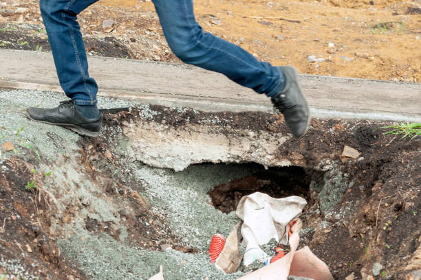 istock a man's feet jump over a pit next to an asphalt sidewalk. 1412435814