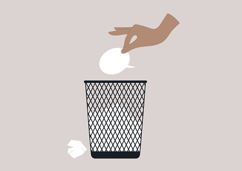 A hand throwing a speech bubble in a waste bin, a censorship concept