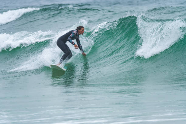 istock Female surfer riding a wave 1412439038