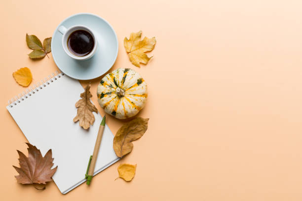 istock Autumn composition: fallen leaves and notebook mock up on colored background. Top view. Flat lay with copy space 1412439727