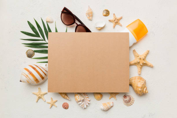 istock Summer time concept with blank greeting card and blank craft paper on colored background. Seashells from ocean shore in the shape of frame separated with space for text top view 1412439762