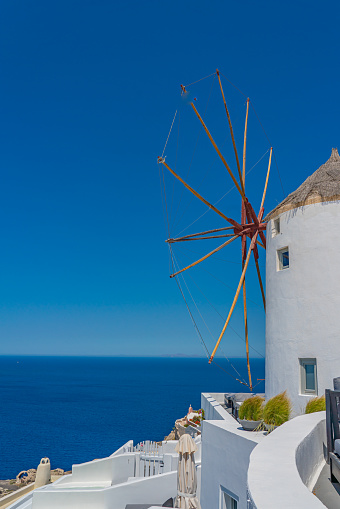 View of a mill in Oia on Santorini island, Greece, background the blue sea, vertical