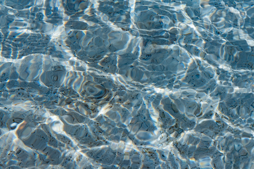 This is a photograph of the sunshine creating a rippled light pattern on the surface of pool water in Tulum, Mexico