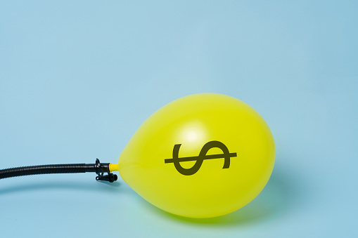 Inflating yellow balloon with dollar sign.  Investme