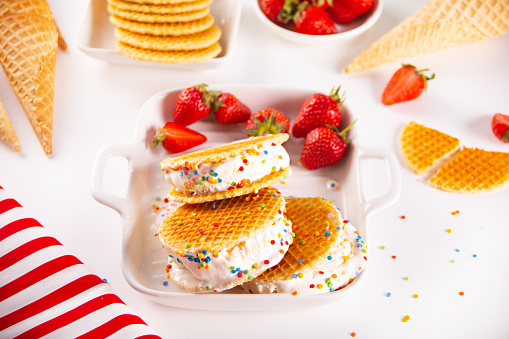 Homemade fresh vanilla strawberries ice cream sandwiches with waffles and waffle cones. Summer delicious tasty dessert
