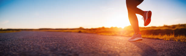 mujer corriendo al aire libre en la puesta de sol de la tarde. - correr fotografías e imágenes de stock