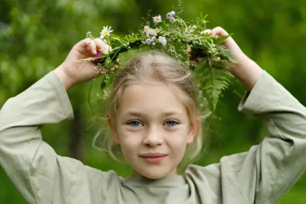 Portrait of a child girl with a wreath on her head, pagan traditions.
