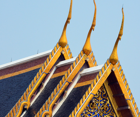 Bangkok, Thailand: Wat Phra Kaew / Temple of the Emerald Buddha, national shrine for the monarchy and the state - chofas on the roof of the ordination hall (Phra Ubosot) - chofa, sky tassel, is a Thai and Lao architectural decorative ornament that adorns the top at the end of wat and palace roofs.  It resembles a tall thin bird and looks hornlike. The chofa is generally believed to represent the mythical creature Garuda, half bird and half man, who is the vehicle of the Hindu god Vishnu.