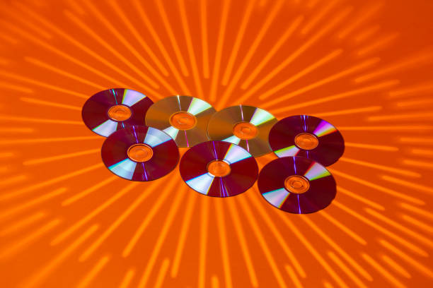 Variety of Arranged CD Disks or DVD Disks on Orange Background With Different Circular Rays Patterns or Masks.Horizontal Image