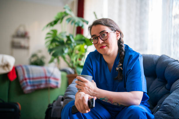 Healthcare worker relaxing at home stock photo