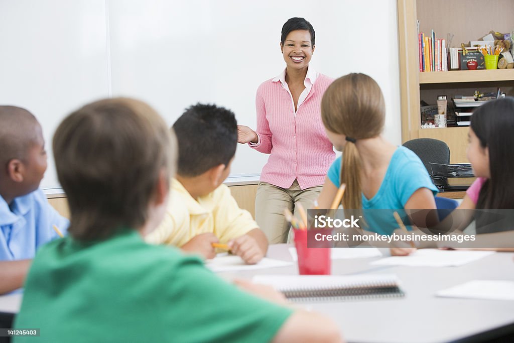 Escuela primaria clase con profesor - Foto de stock de Adulto maduro libre de derechos