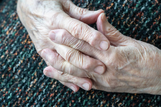closeup wrinkled hands of old white person stock photo